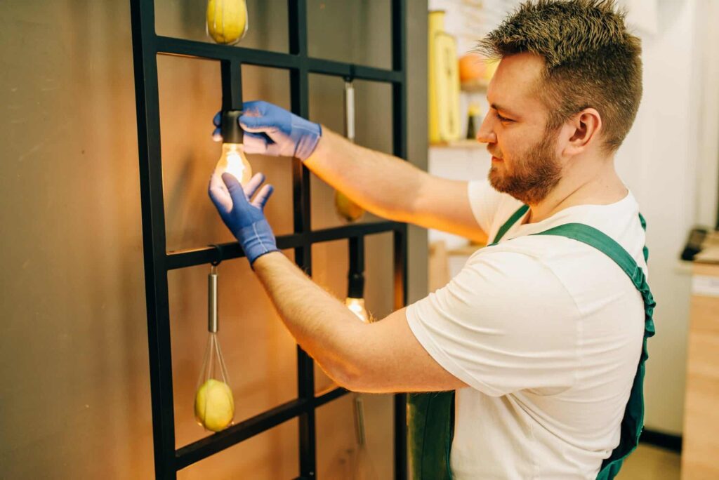 Electrician changes the light bulb, handyman