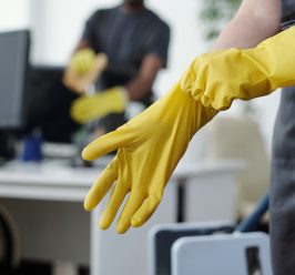 Hands of female worker of contemporary cleaning company putting on gloves